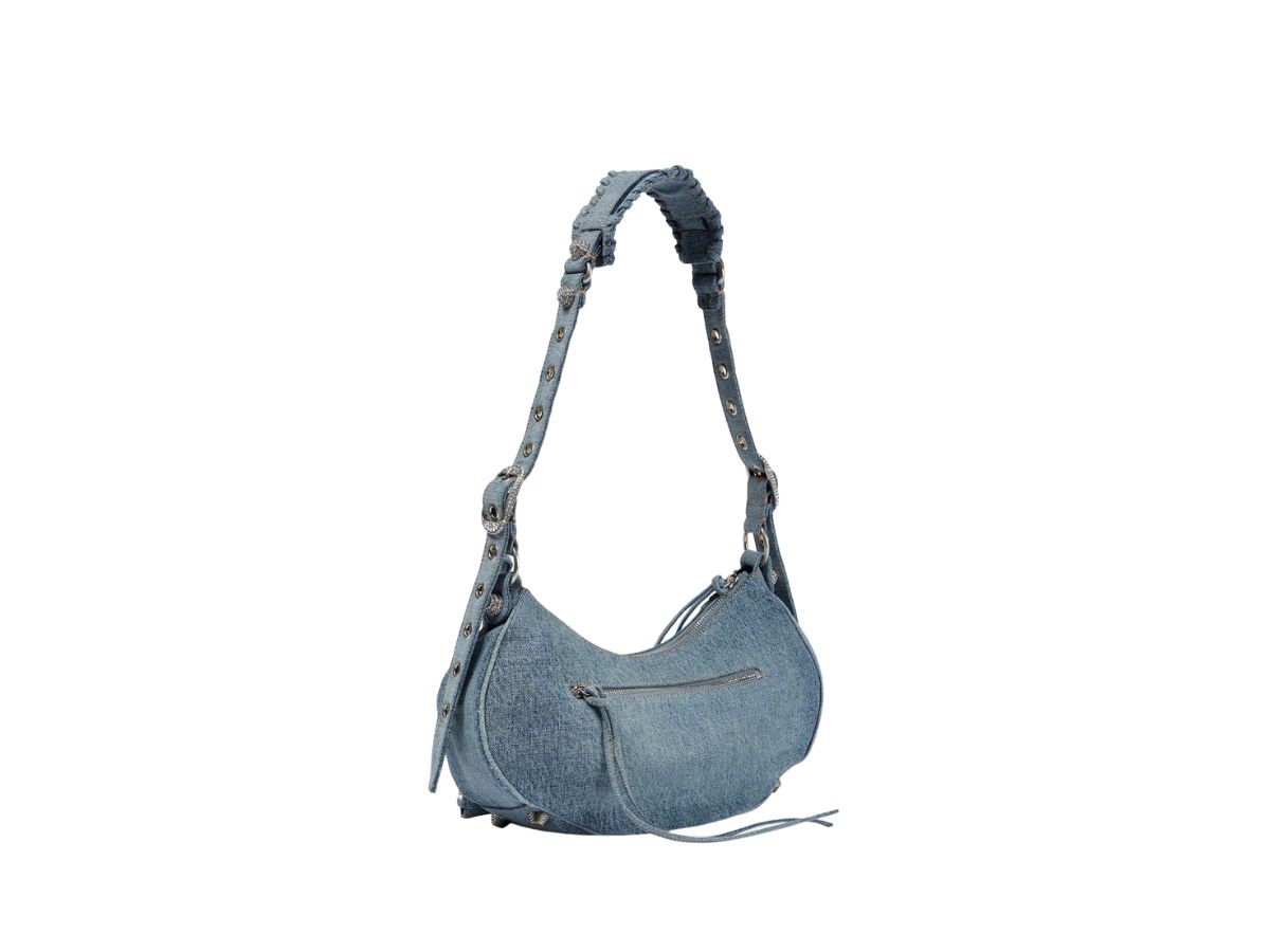https://d2cva83hdk3bwc.cloudfront.net/balenciaga-le-cagole-small-shoulder-bag-in-blue-washed-and-frayed-denim-with-aged-silver-hardware-and-rhinestones-2.jpg