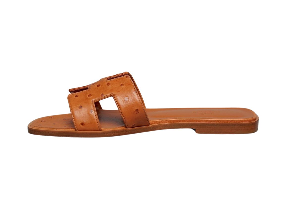 https://d2cva83hdk3bwc.cloudfront.net/hermes-oran-sandal-in-ostrich-with-iconic-h-cut-out-cognac--w--2.jpg