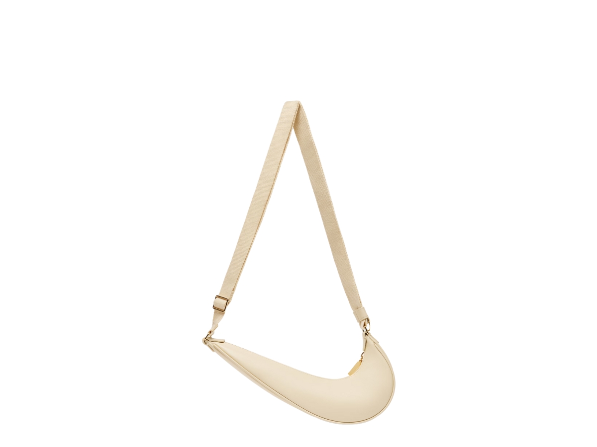 https://d2cva83hdk3bwc.cloudfront.net/jacquemus-le-sac-swoosh-jacquemus-nike-in-cowskin-with-gold-metal-logo-hardware-ivory-3.jpg