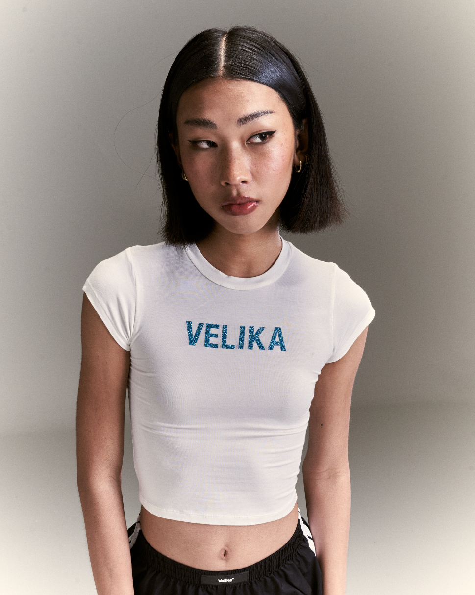 https://d2cva83hdk3bwc.cloudfront.net/velika_velika-%7C-glitter-logo-baby-tee--white--5.jpg